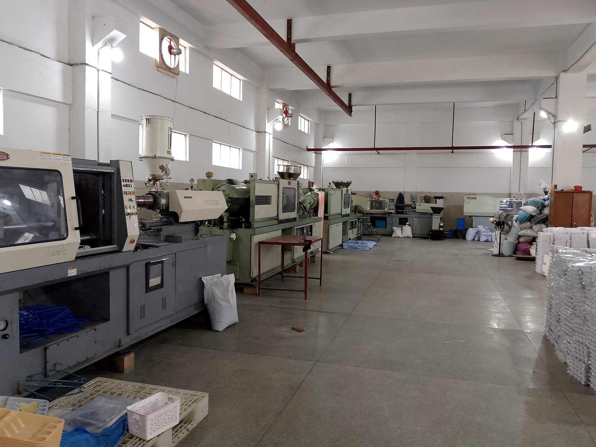 Row of Nissei injection molding machines running on the Plasteks production floor
